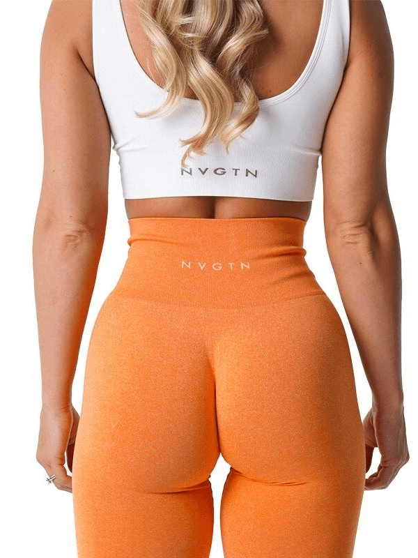 Back view of orange tight elastic women's leggings with high waist, perfect for yoga, fitness, and running, paired with a white sports bra.